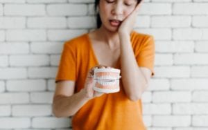 Woman Displaying Model With Tooth Pain