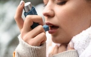 Woman using an asthma inhaler